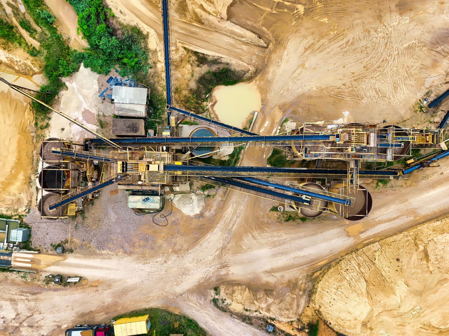 Top-down view of a sprawling industrial mining site featuring heavy machinery and detailed terrain.