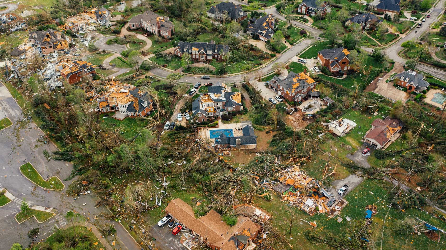 Aerial view of small settlement with destroyed houses and bent uprooted trees after hurricane