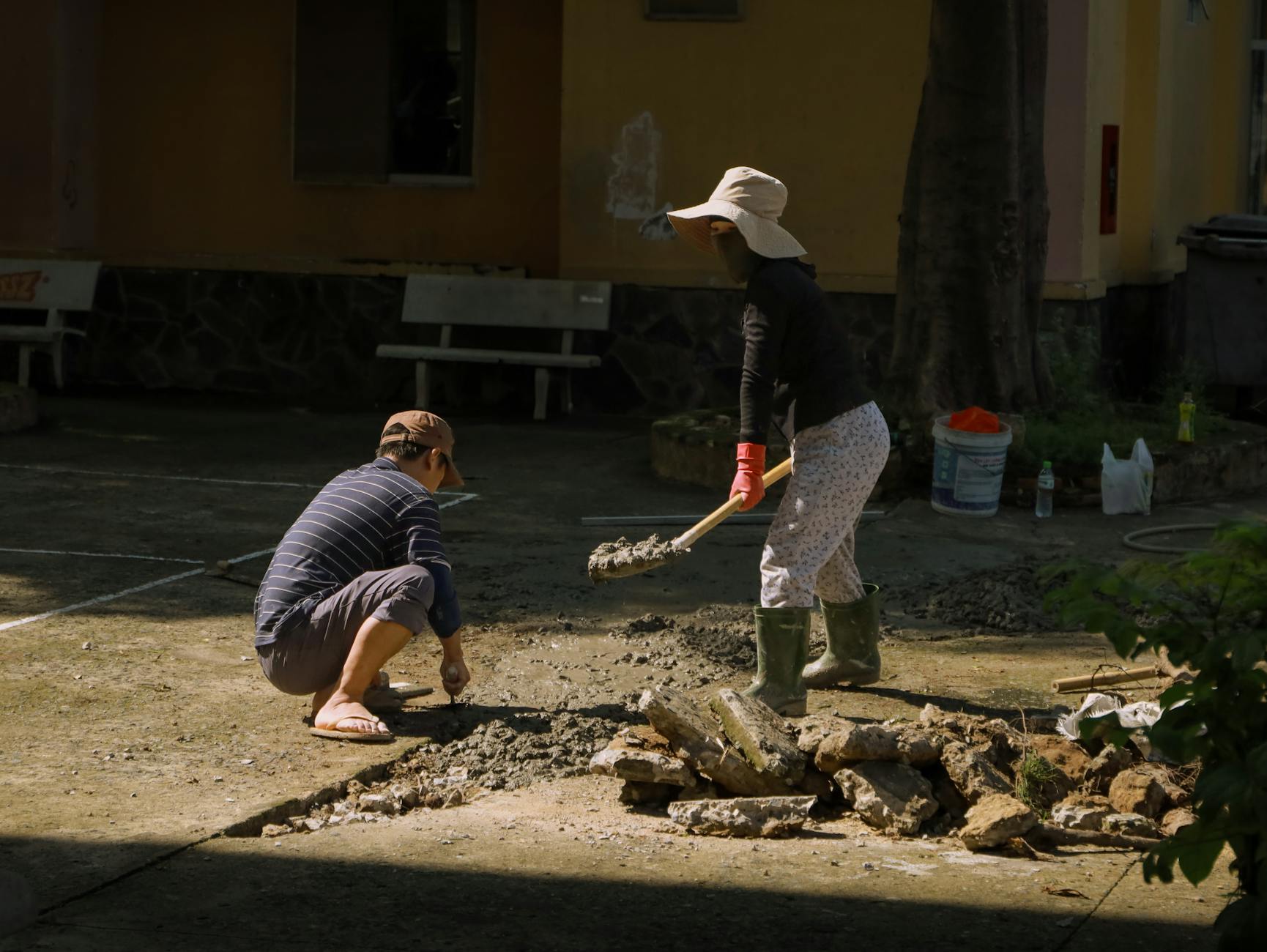 Two people engaged in concrete work outdoors in Hồ Chí Minh City, Vietnam.