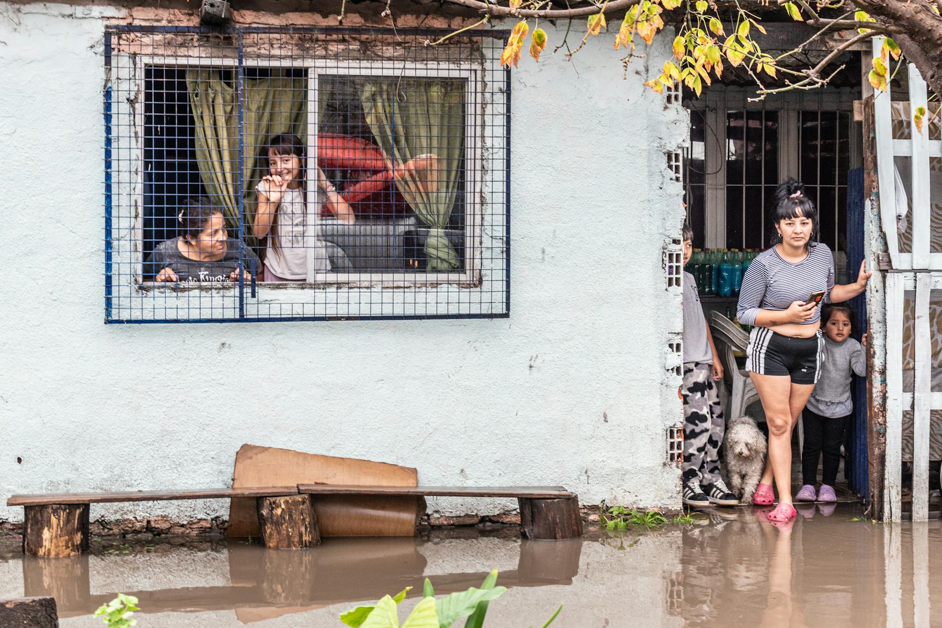 Families coping with flooding in Buenos Aires, reflecting climate impact.