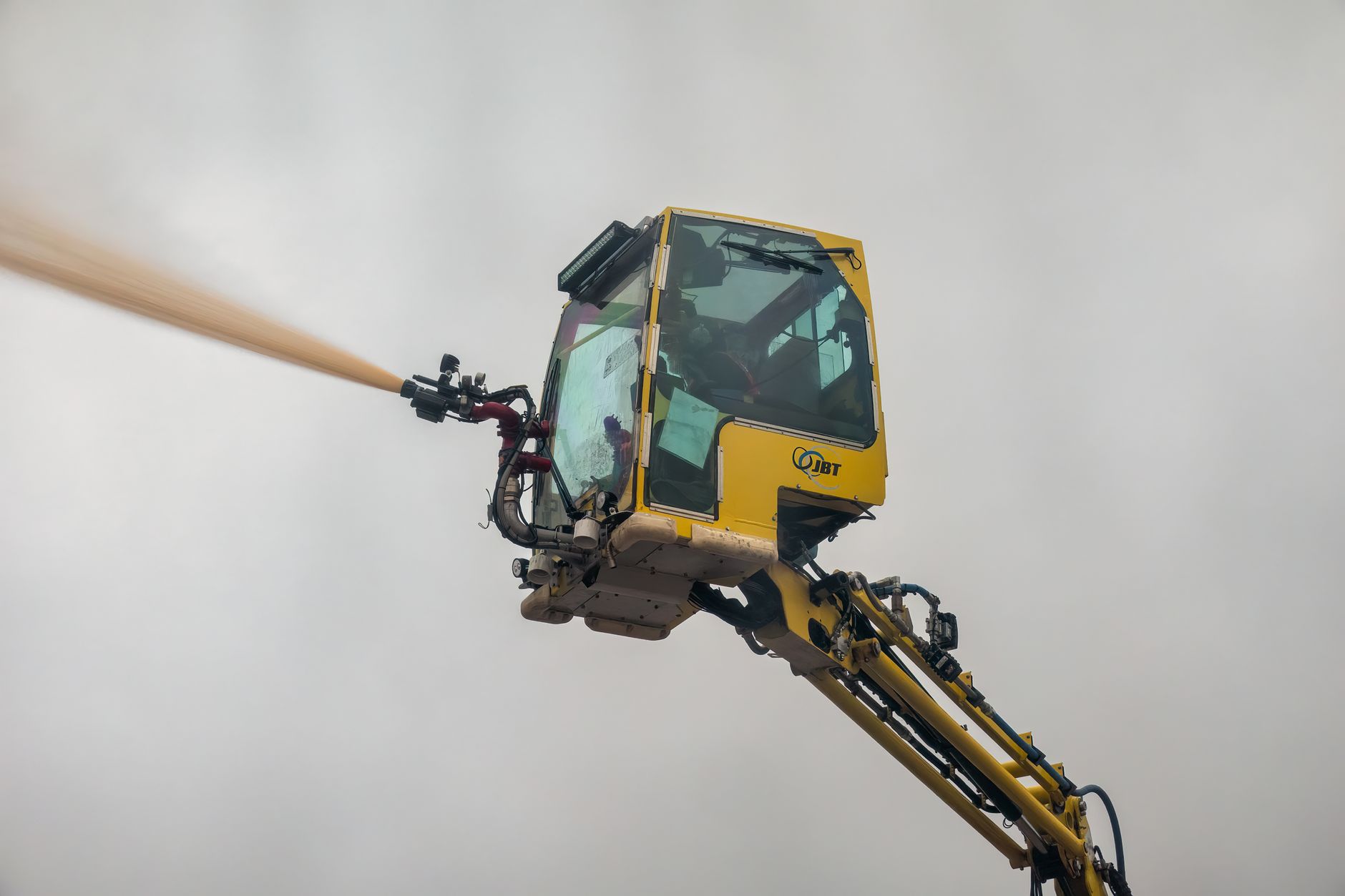 Close-up view of an aerial firefighting machine spraying water during a safety drill.