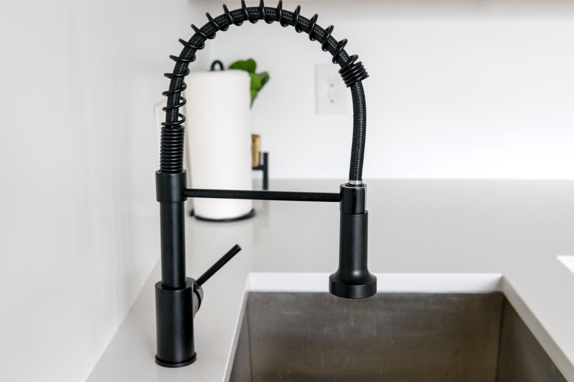 Sleek black faucet on white countertop in modern kitchen. Ideal for minimalist and contemporary designs.