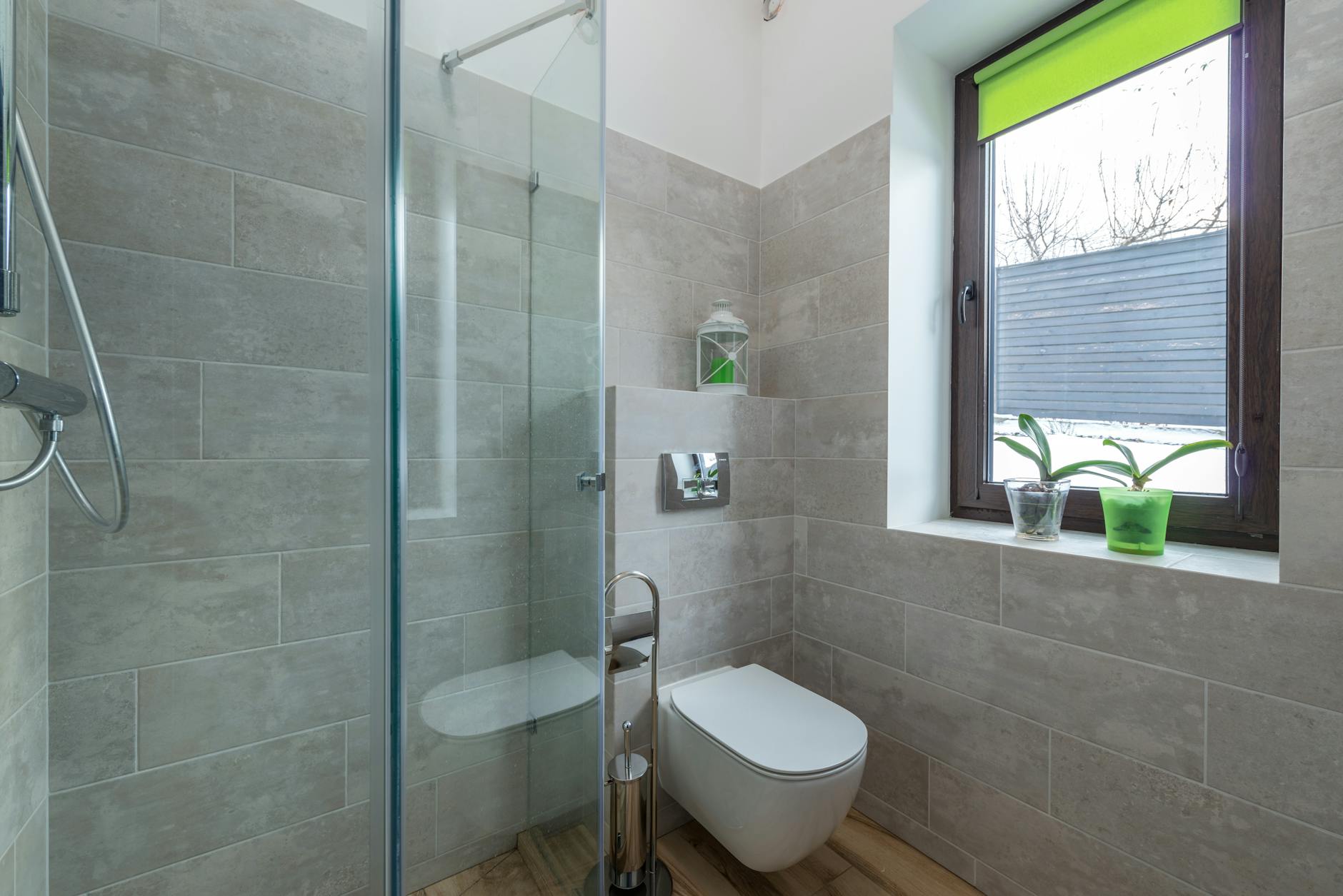 Contemporary bathroom featuring a glass shower, window, and minimalist design elements.