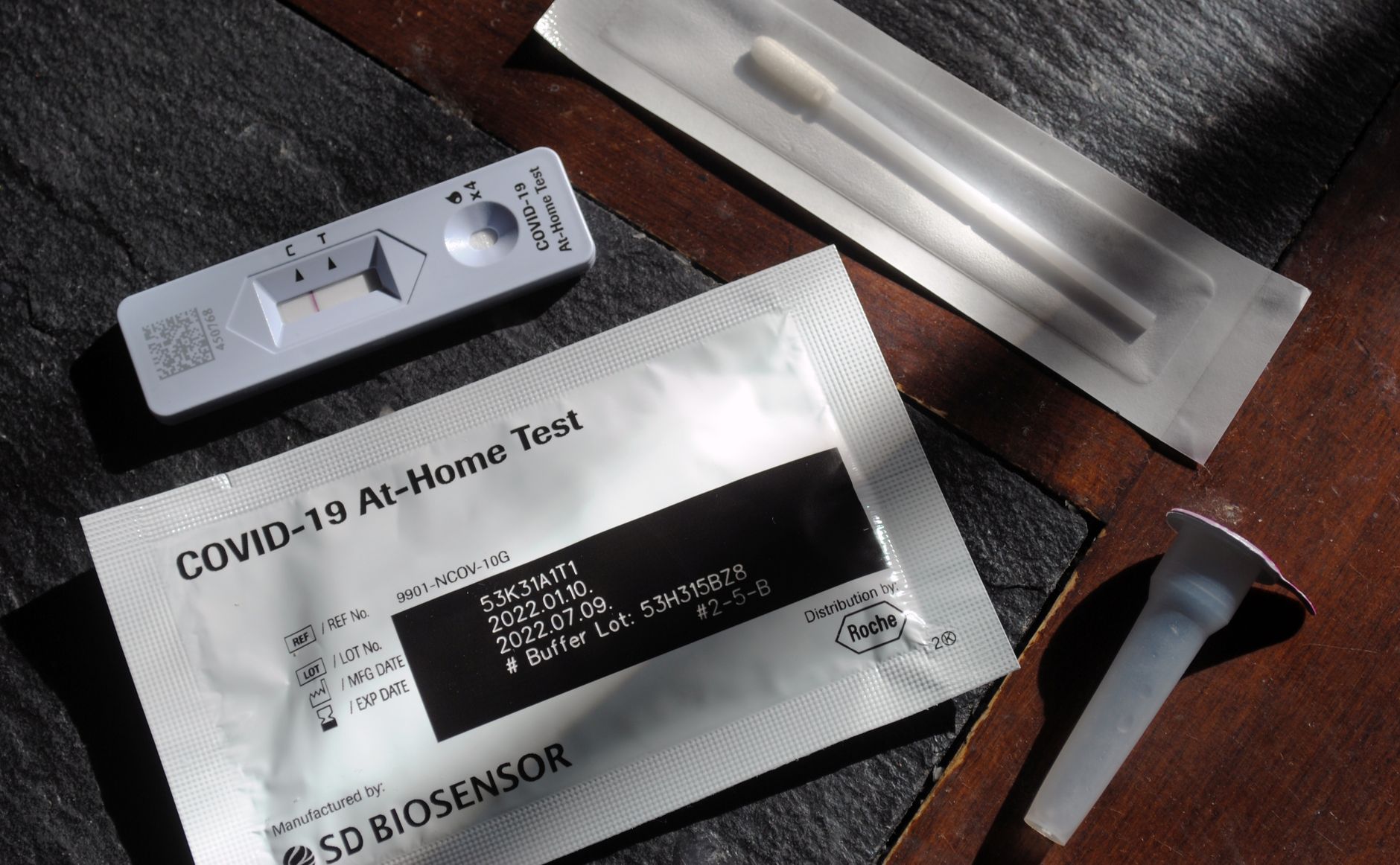 Close-up of a COVID-19 at-home test kit with packaging and test components displayed.