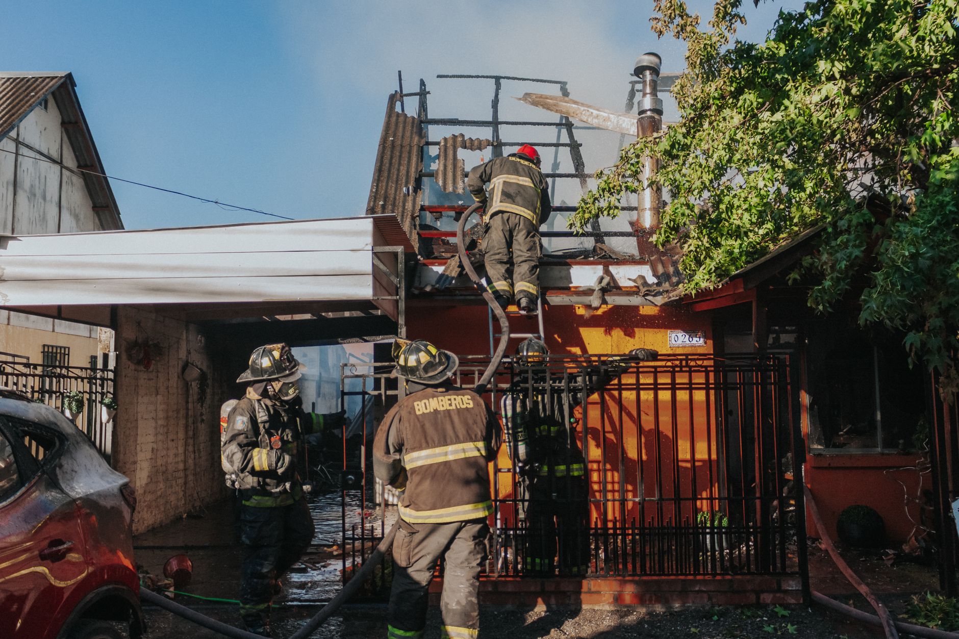 Firefighters working to extinguish a house fire, showcasing bravery and teamwork outdoors.