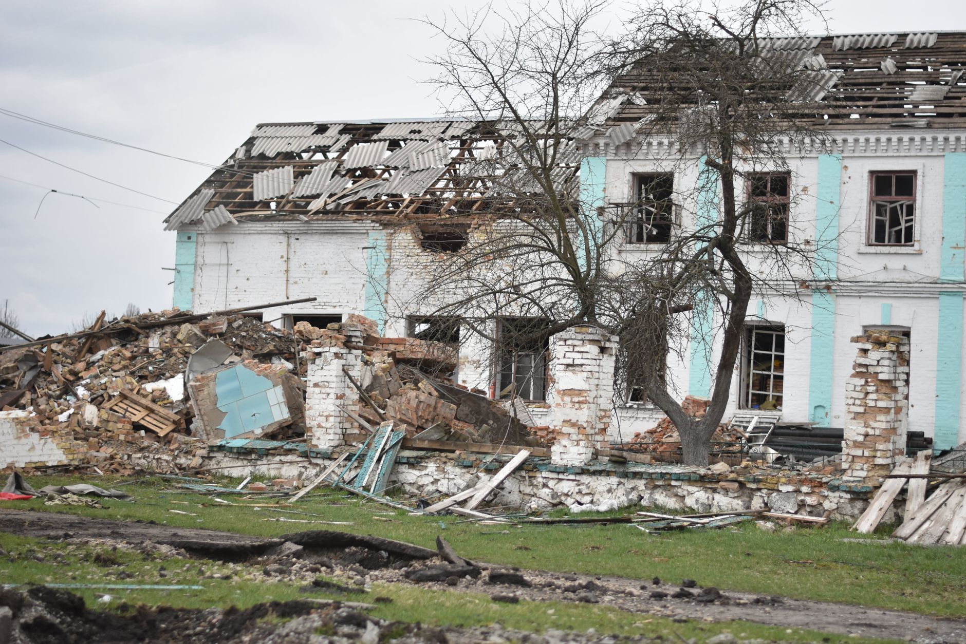 A dilapidated structure with collapsed roof and crumbling walls, set outdoors.