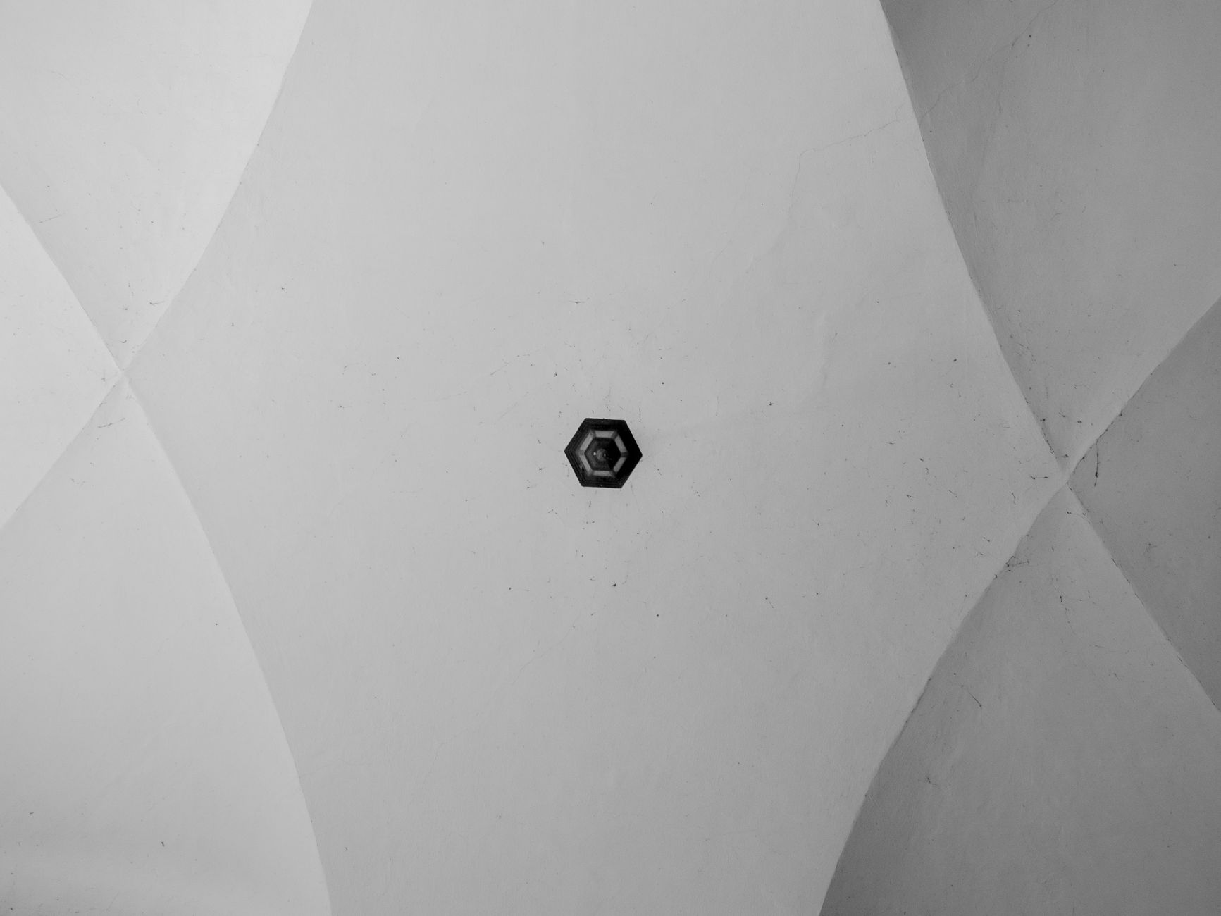 From below of black and white geometric ceiling with chandelier as abstract background
