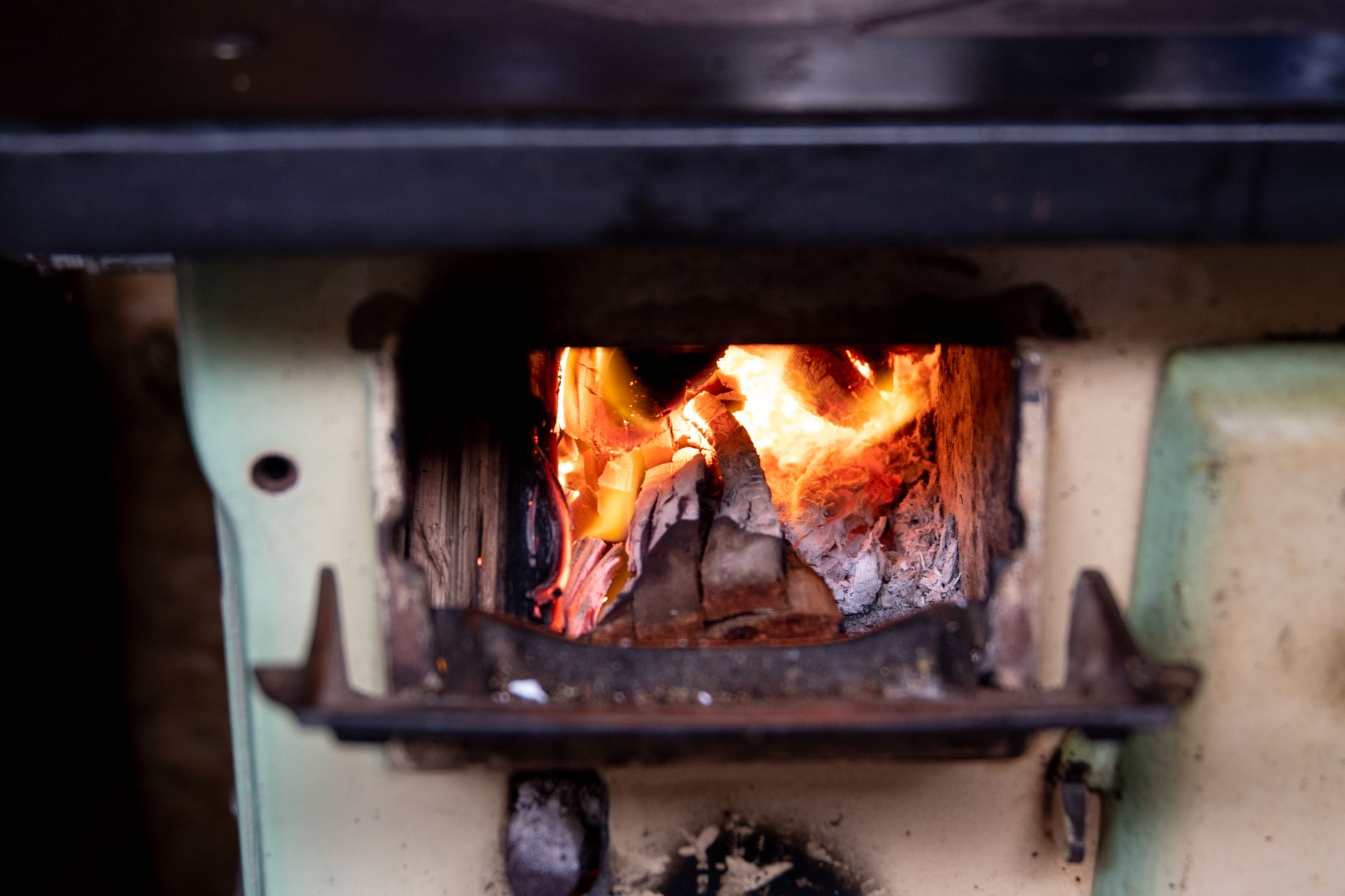 Close-up of a burning firewood in a vintage stove, providing warmth and nostalgia.