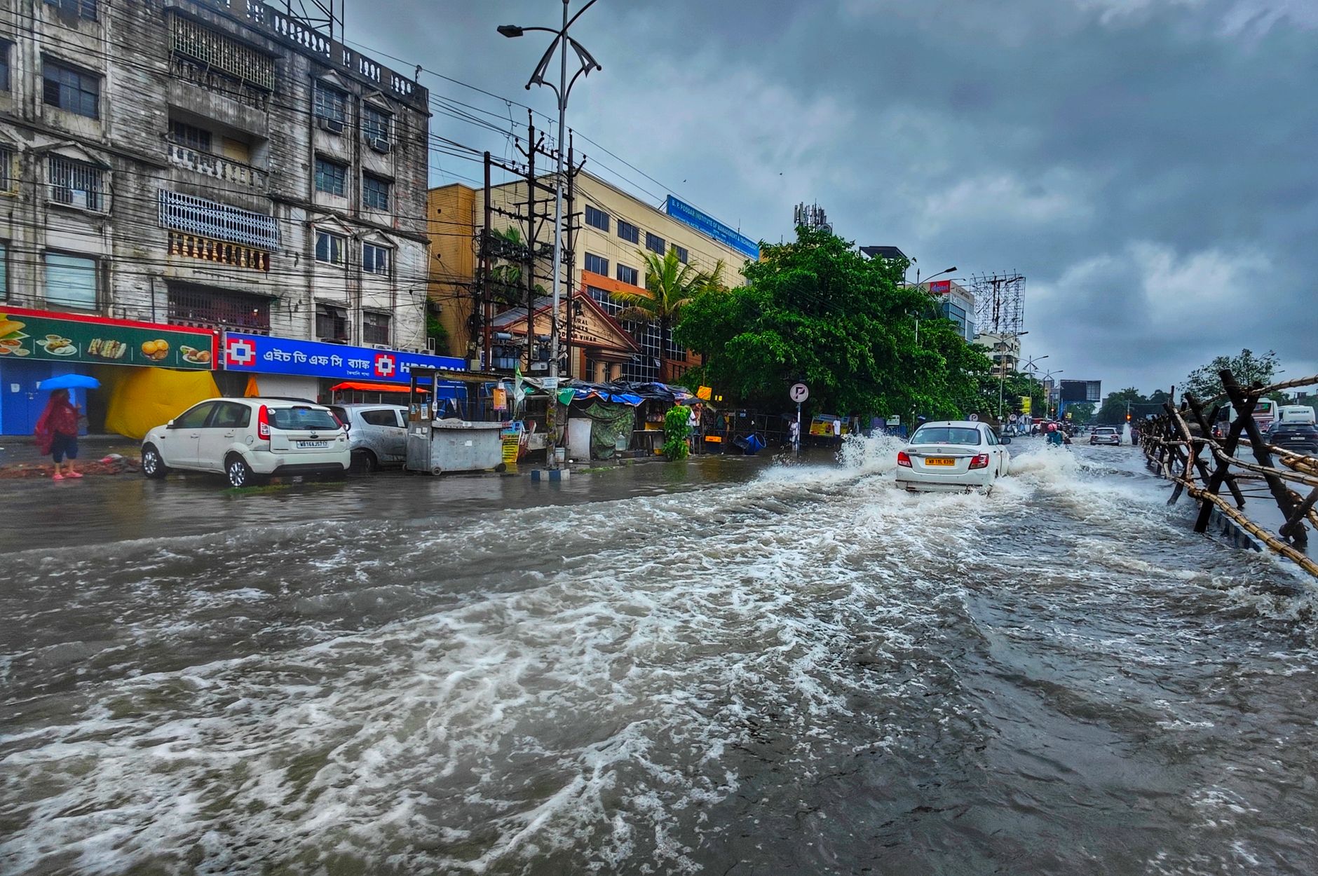 A busy urban street in Kolkata flooded after heavy monsoon rains, showcasing urban infrastructure challenges.