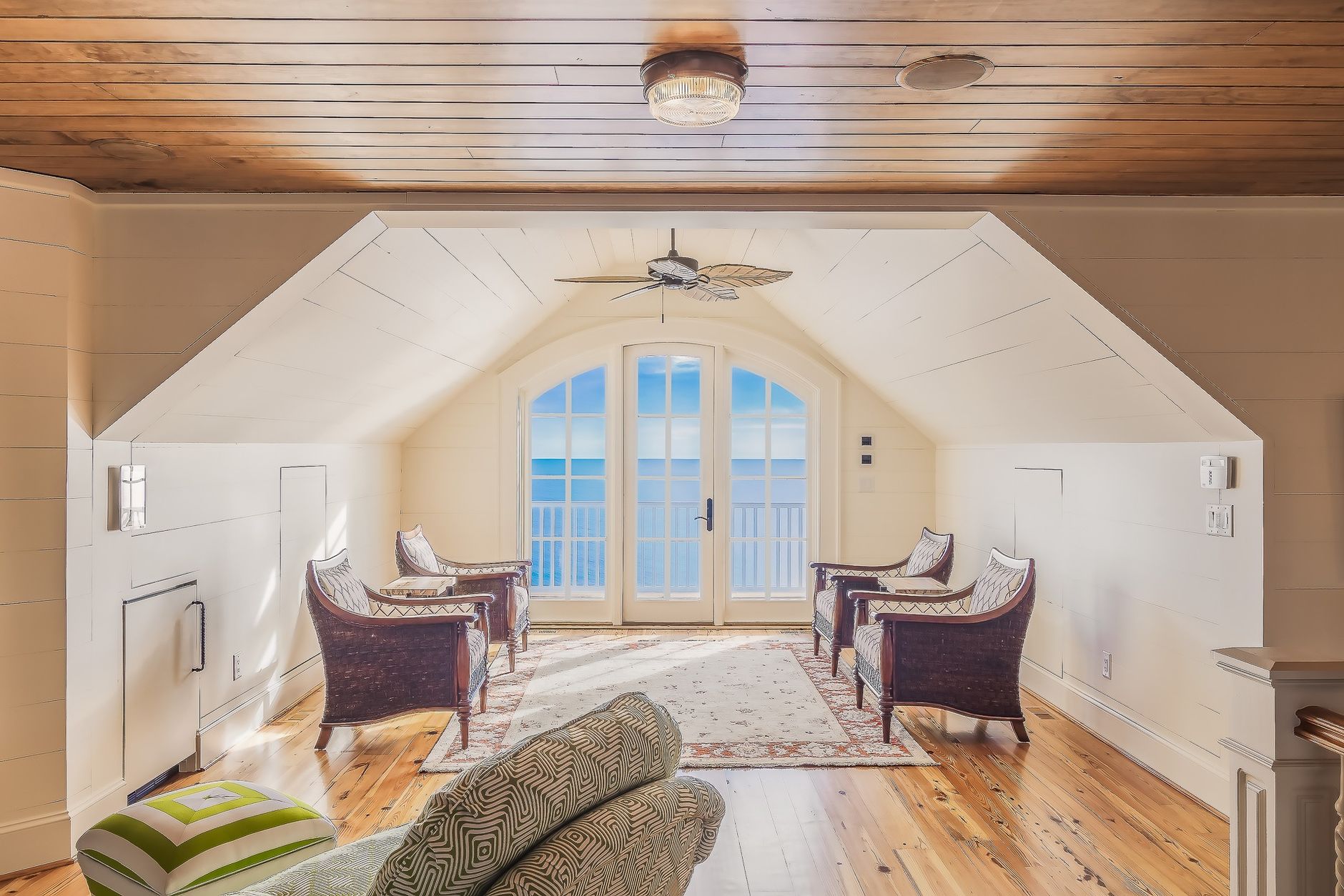 Bright and luxurious loft overlooking the ocean, featuring modern furniture and design.