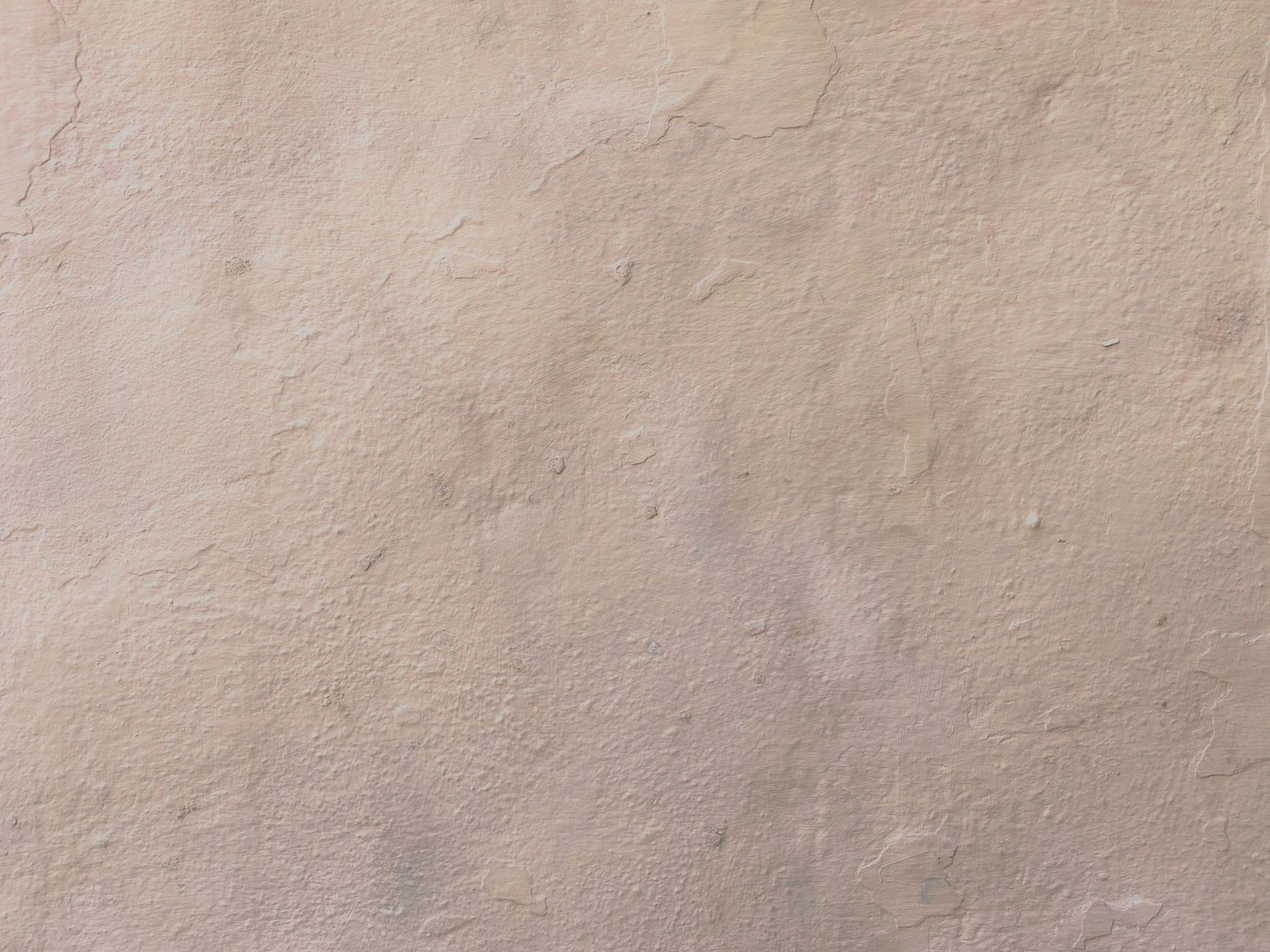 Close-up of a beige textured plaster wall surface, ideal for backgrounds.