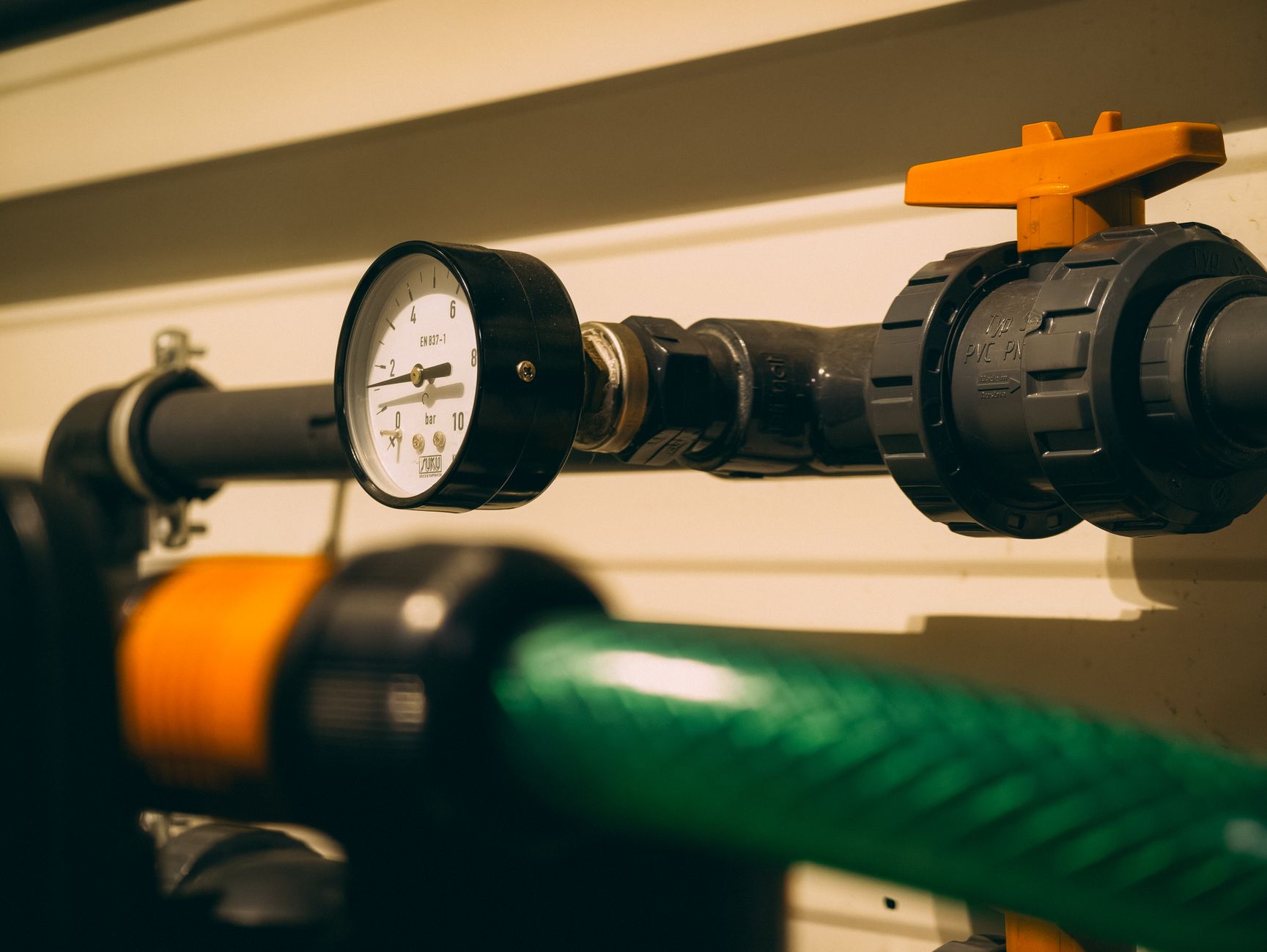 Close-up view of an industrial pressure gauge attached to piping. Ideal for engineering or industry visuals.