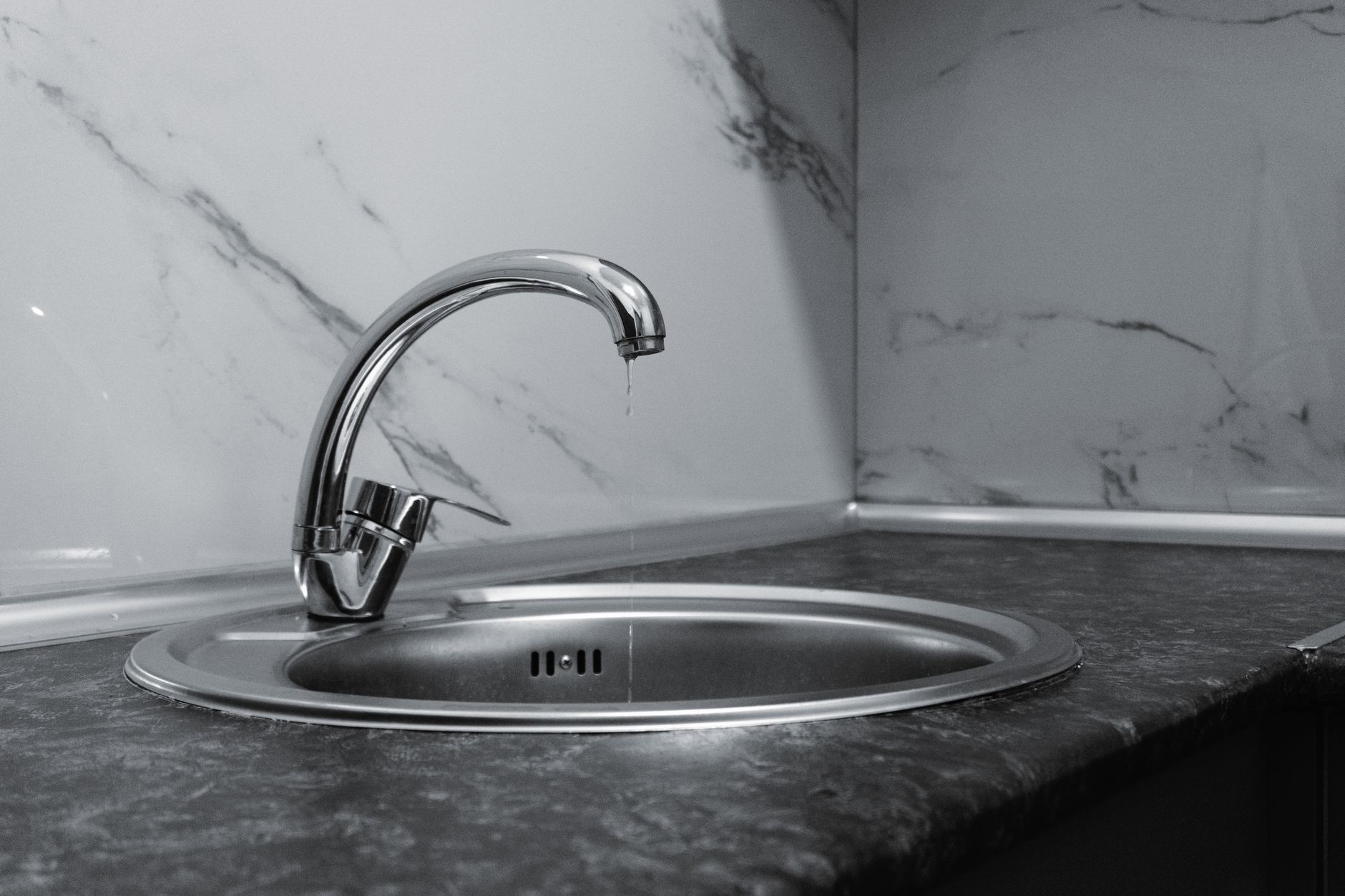 A clean and modern kitchen sink with a chrome faucet, highlighting minimalist design and water conservation.