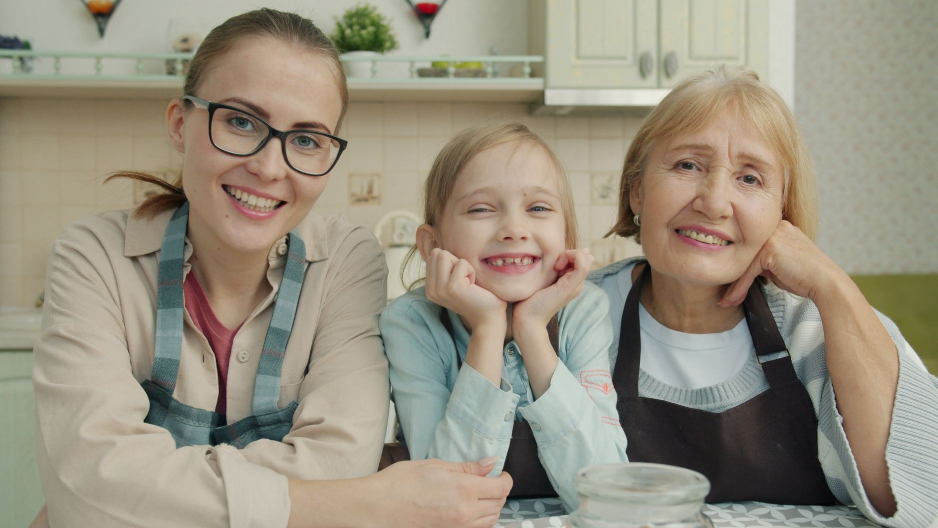 Happy family of three generations smiling together in kitchen.
