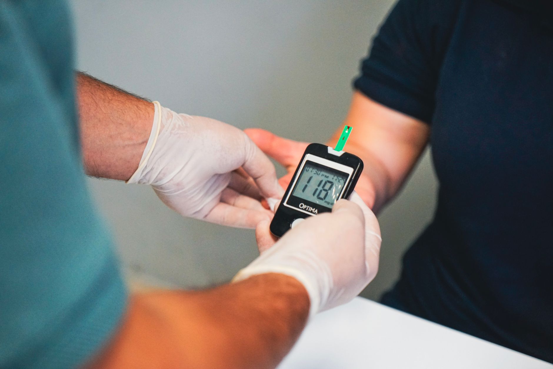 Healthcare professional using glucometer to check blood sugar level, indicating diabetes management.