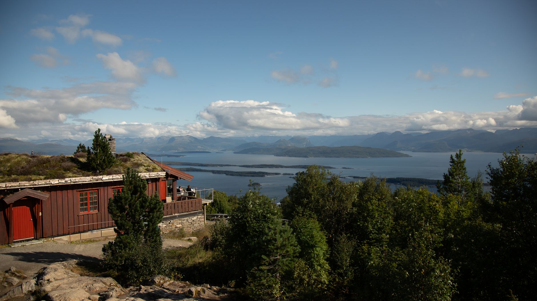 Capture of a serene fjord view with traditional Norwegian cabin in foreground, Molde, Norway.