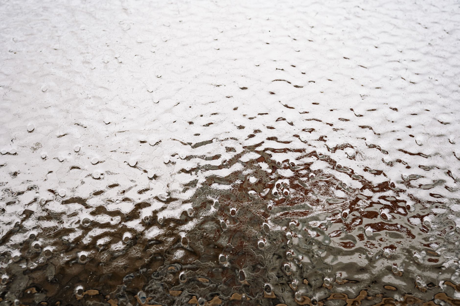Detailed close-up photo of icy texture on a glass surface, showcasing frost patterns.