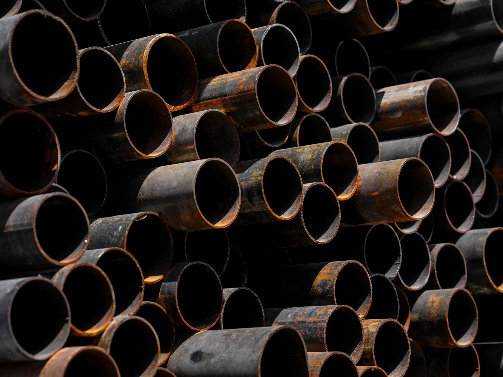 Close-up of stacked rusty pipes showcasing industrial recycling processes.