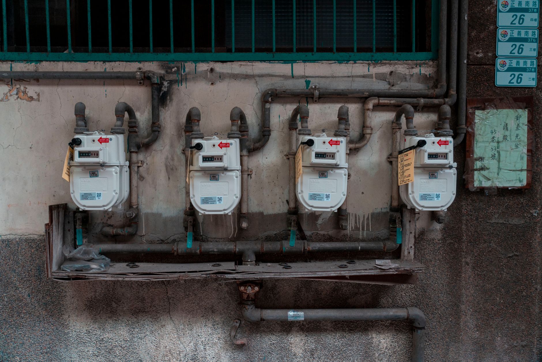 Four gas meters mounted on an exterior wall, showcasing urban utility infrastructure.
