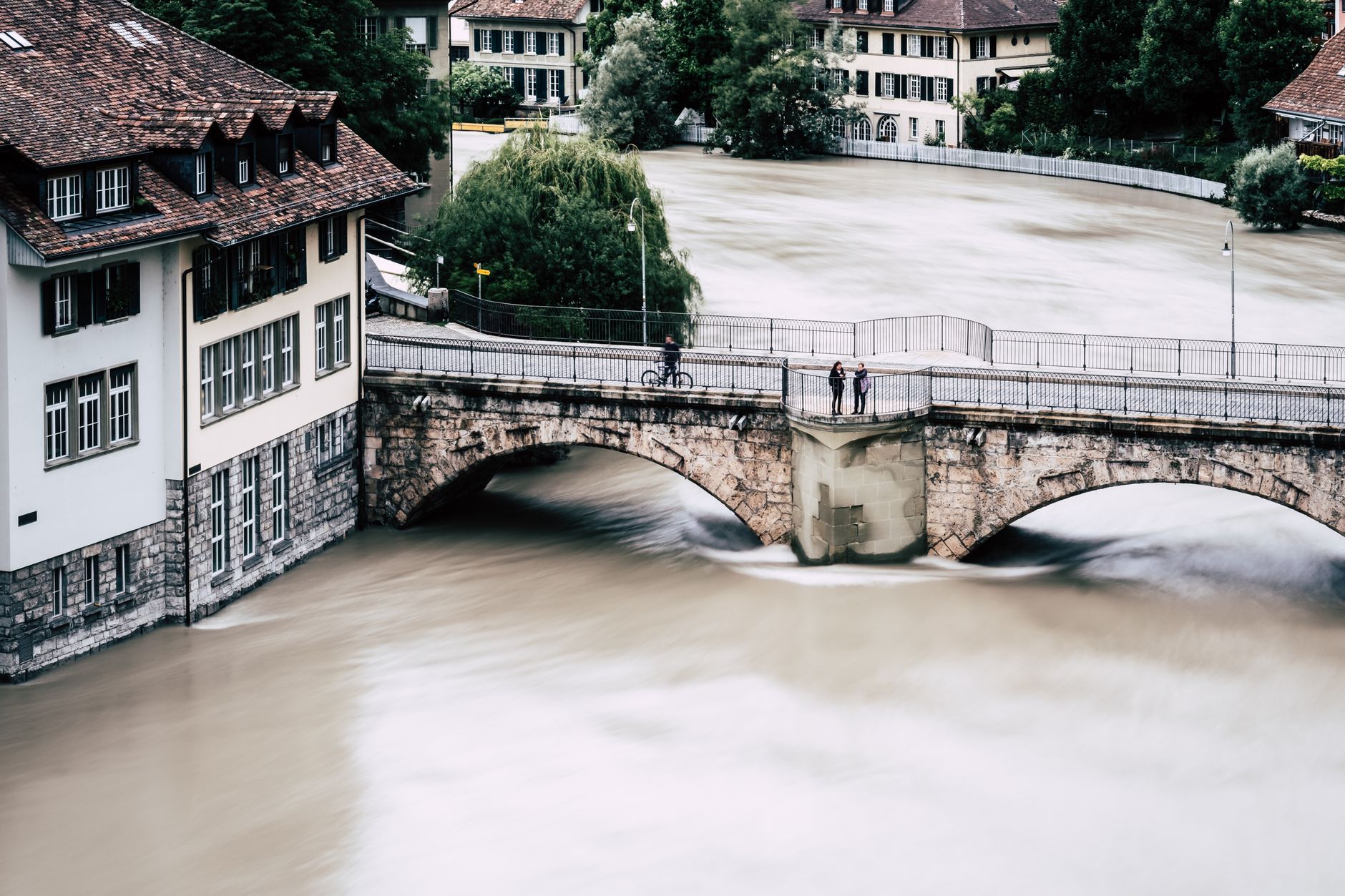 Aerial view of a historic bridge over a flooded river in Bern, Switzerland.
