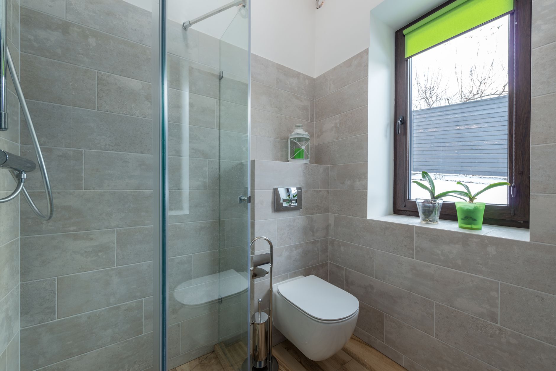 Contemporary bathroom featuring a glass shower, window, and minimalist design elements.
